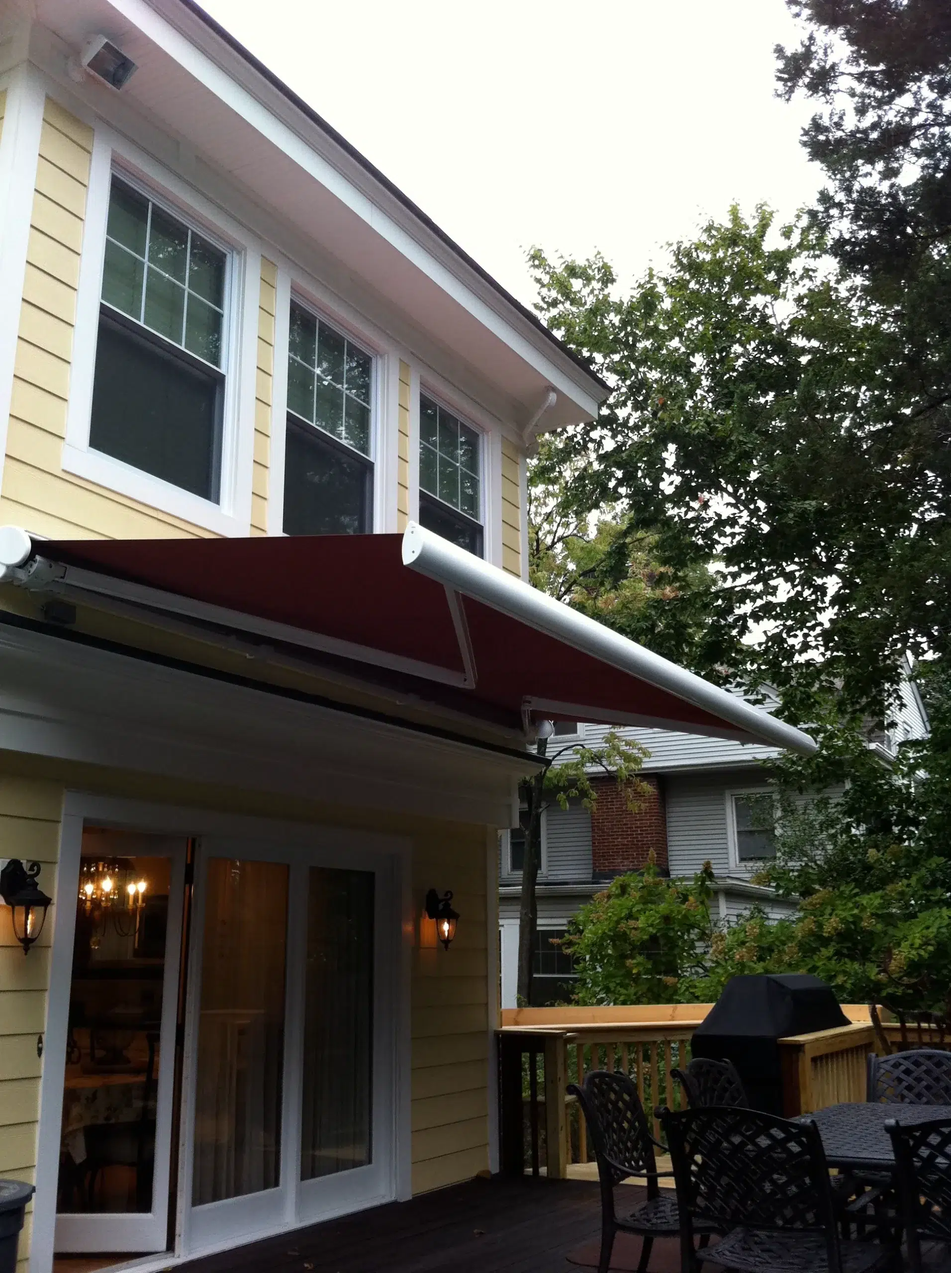 A retractable awning extending over an outdoor dining space, providing shade and shelter from the sun.